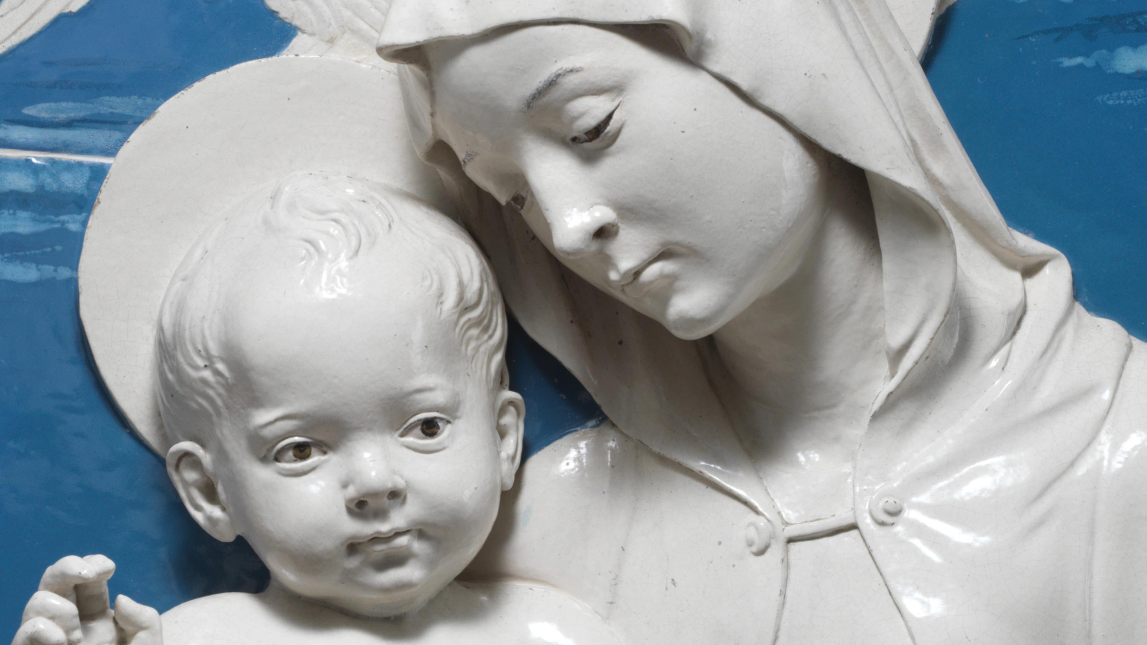 Sculpture of woman and child against blue background